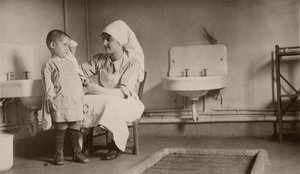 Infirmière soignant un enfant malade aux colonies de Passay et Saint-Quentin pour réfugiés et orphelins - American Photographer